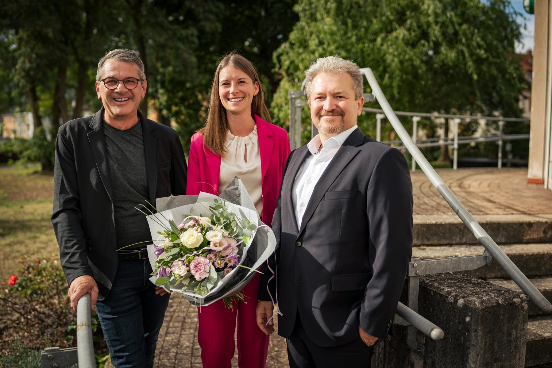 OB Wolfram Britz, Ann-Christin Karcher mit einem Blumenstrauß in der Hand und Wohnbau-Geschäftsführer Jurij Kern